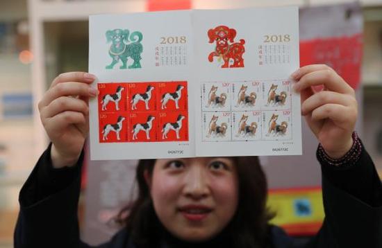 1月5日,在浙江省宁波市一邮政网点,工作人员展示《戊戌年》生肖邮票小版张。 新华社 图