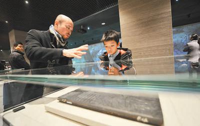 工作人员在向小朋友讲解木雕版孔子圣迹图 (人民视觉 杨国庆摄)